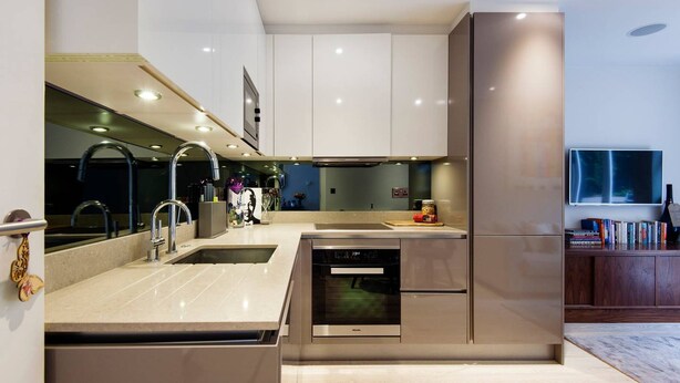 A modern kitchen with stainless steel appliances, a double sink, and a built-in oven. - The Bohemian Rhapsody- Garden Apartment in Hampstead - by Out of Office Lifestyle (London)