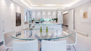 A modern kitchen with a central island, white cabinetry, and stainless steel appliances. - The White Peace Garden 3 bed Hampstead - by Out of Office Lifestyle (London)