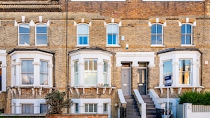 A row of terraced houses with bay windows and a front door. - The Blooming Minimalist- by Out of Office Lifestyle (London)