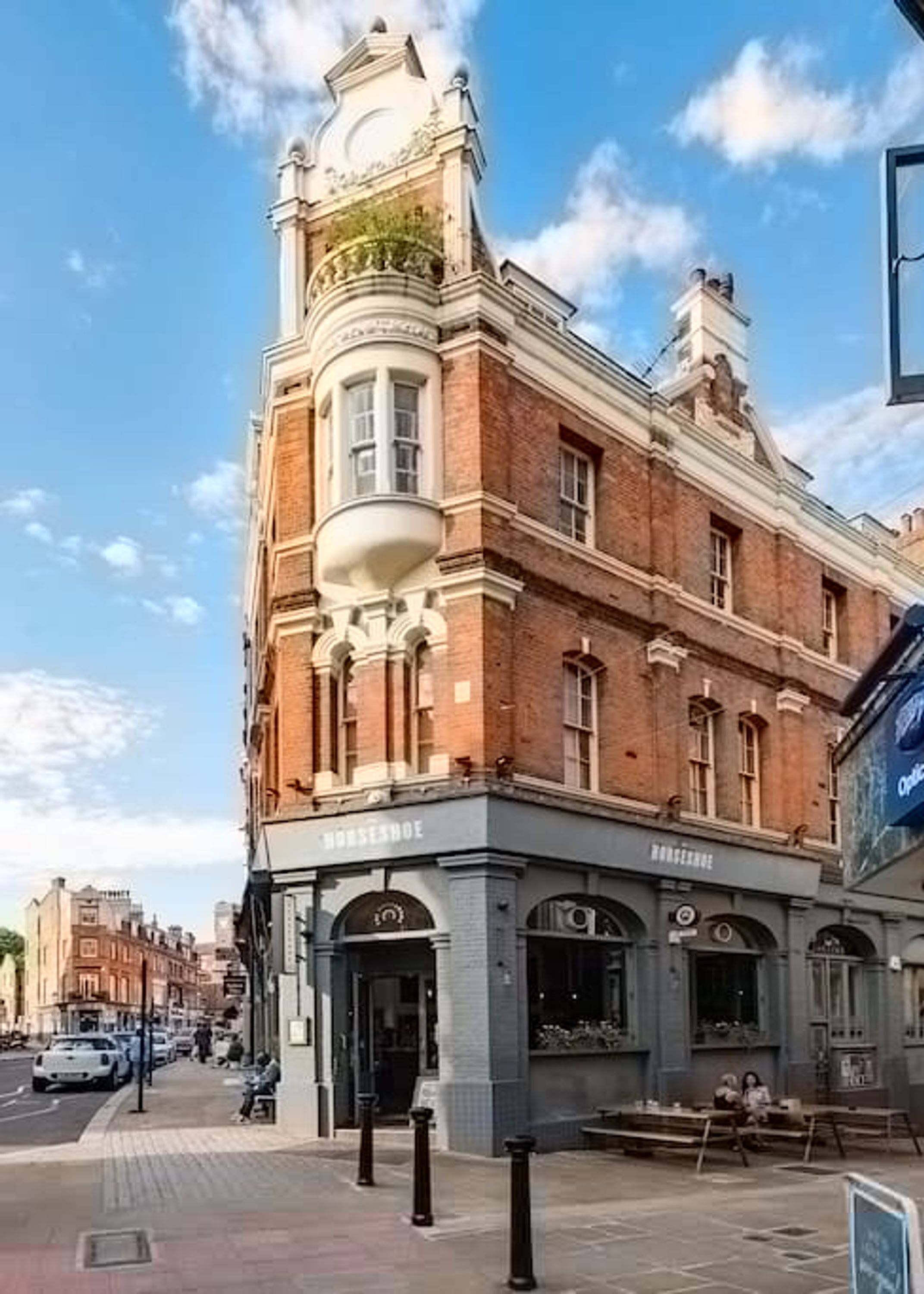 A historic building with a corner turret and a ground-level entrance labeled "HORSESHOE."