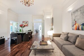 A spacious living room with a dining area, a sofa, and a coffee table. - The Family Getaway - by Out of Office Lifestyle (London)