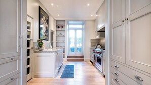 A modern kitchen with white cabinetry, a central island, and a view to the outside.