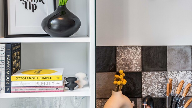 A kitchen with a modern design, featuring a black pendant light, a coffee maker, and a tray with cups and a mug. - Lady on the Lane- 2 bed Primrose Hill - by Out of Office Lifestyle (London)
