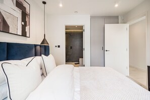 A modern bedroom with a large bed, a headboard, a bedside table, and a wardrobe. - The Modern Glasshouse - by Out of Office Lifestyle (London)