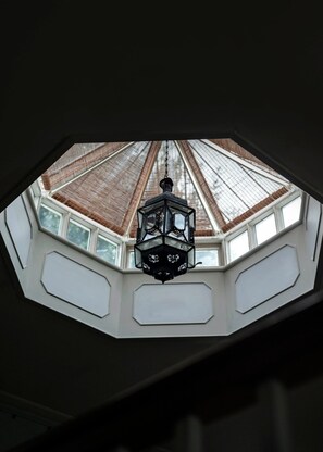 Une lucarne de forme hexagonale et une lanterne suspendue.
