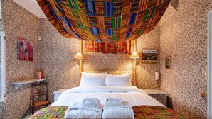 A hotel room with a patterned wallpaper, a bed with white linens, two bedside lamps, and a colorful ceiling. - The Kensington Gatehouse - by Out of Office Lifestyle (London)