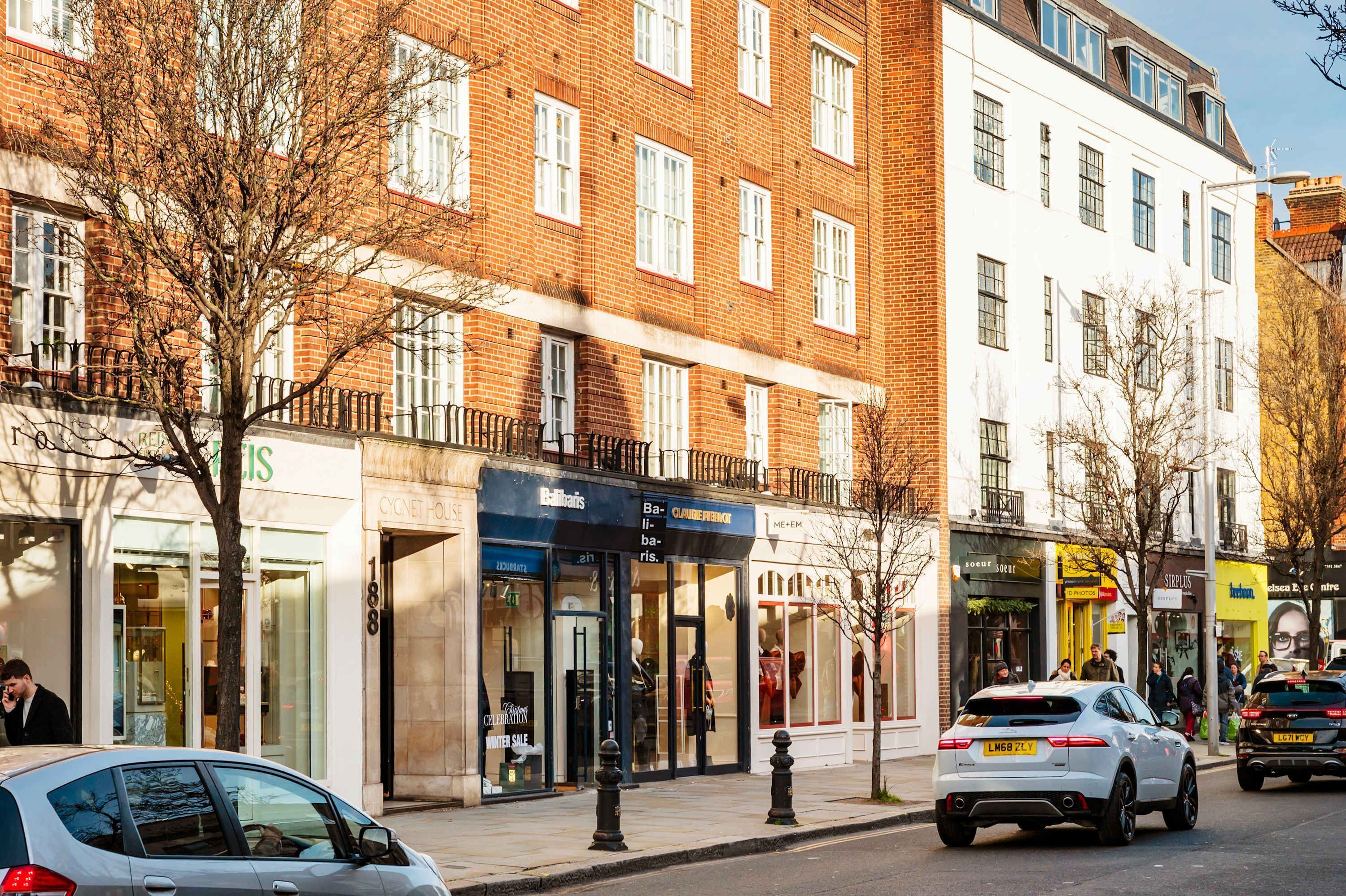 A street view with a row of shops, including a bakery and a clothing store.