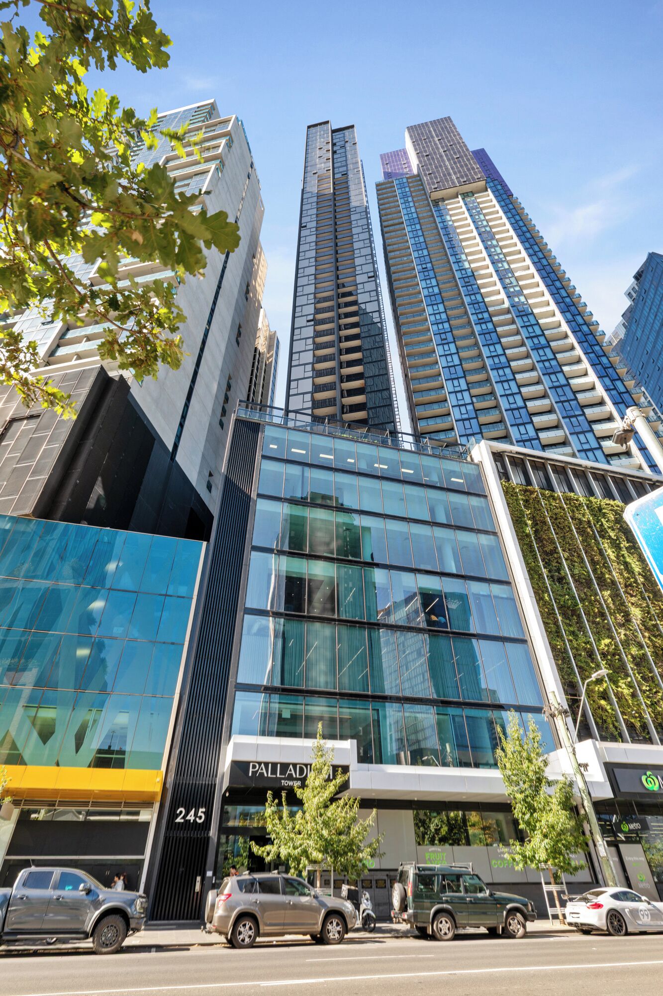A modern building with a glass facade, labeled "Palladium Tower 245".