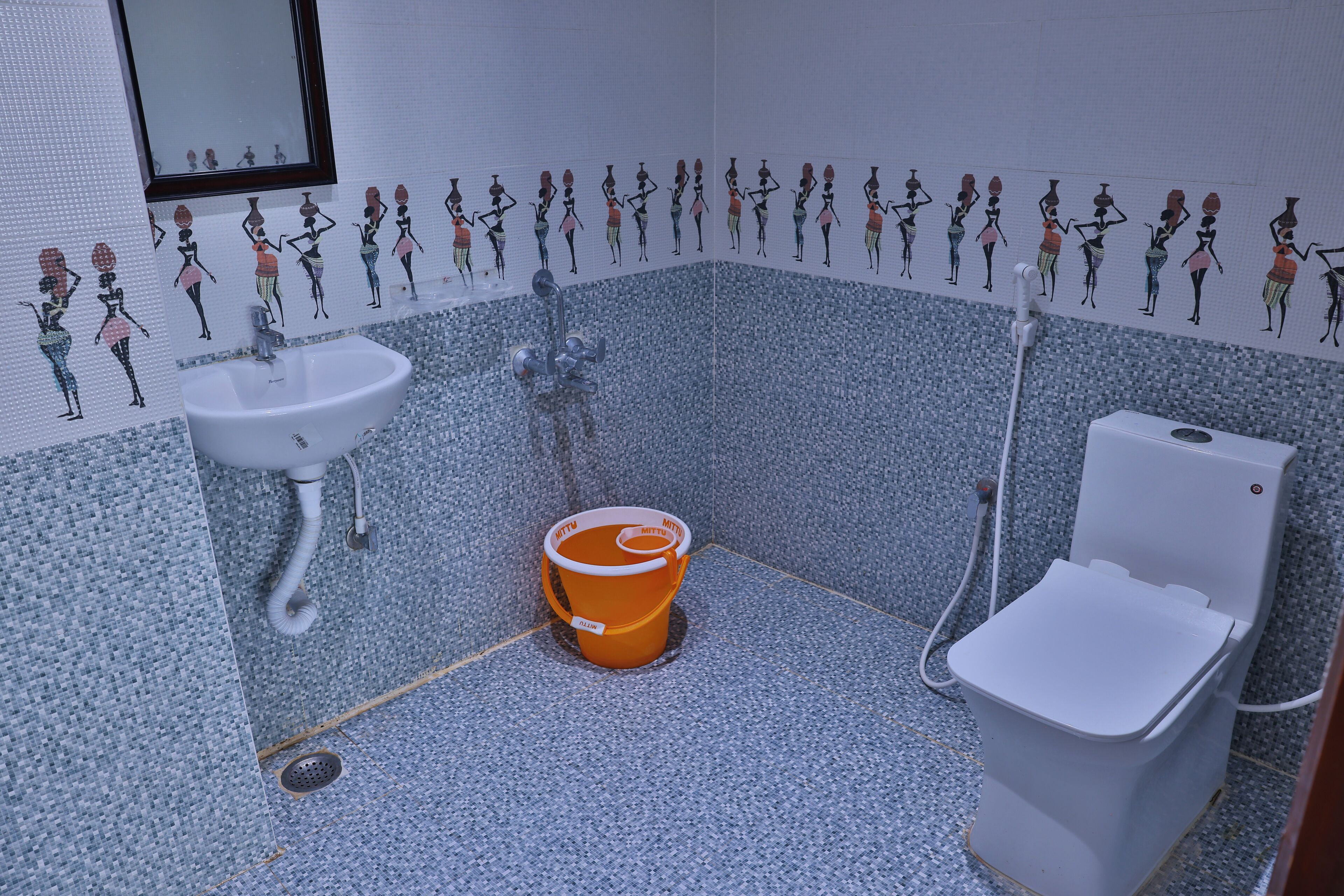 A bathroom with a sink, toilet, and a bucket.