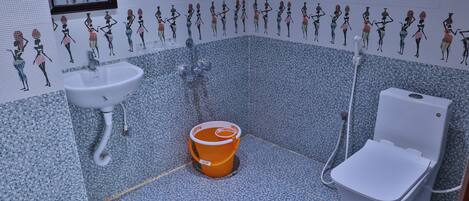 A bathroom with a sink, toilet, and a bucket.