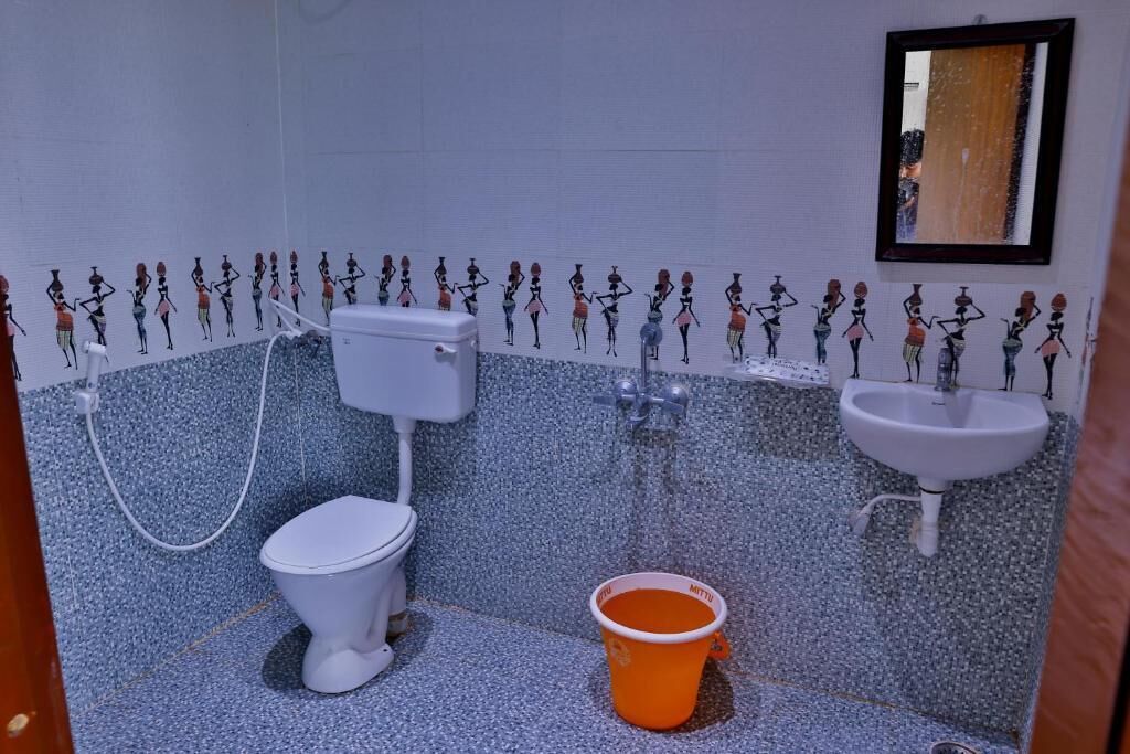 Ein Badezimmer mit Toilette, Waschbecken und Eimer.