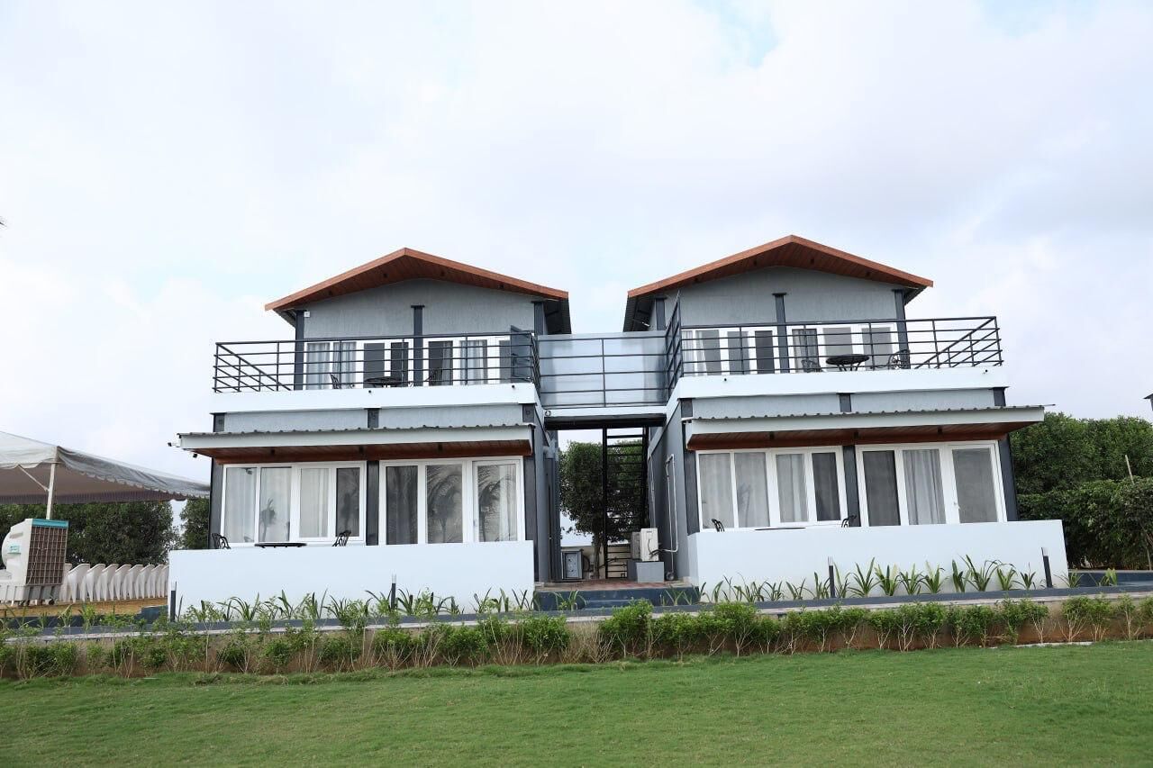 A two-story building with a balcony on each floor, a central staircase, and a flat roof.