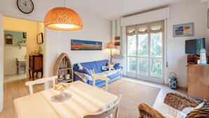 A living room with a dining table, a sofa, a lamp, and a television. - Stylish flat balcony near Rapallo Castle (Rapallo)