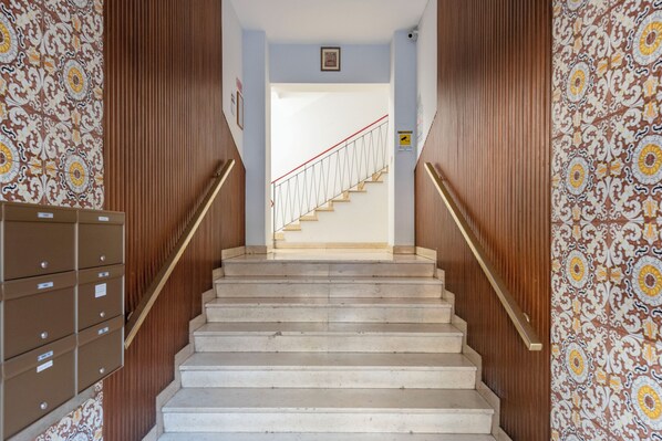 A staircase with wooden handrails and patterned wallpaper on the walls. - Stylish flat balcony near Rapallo Castle (Rapallo)