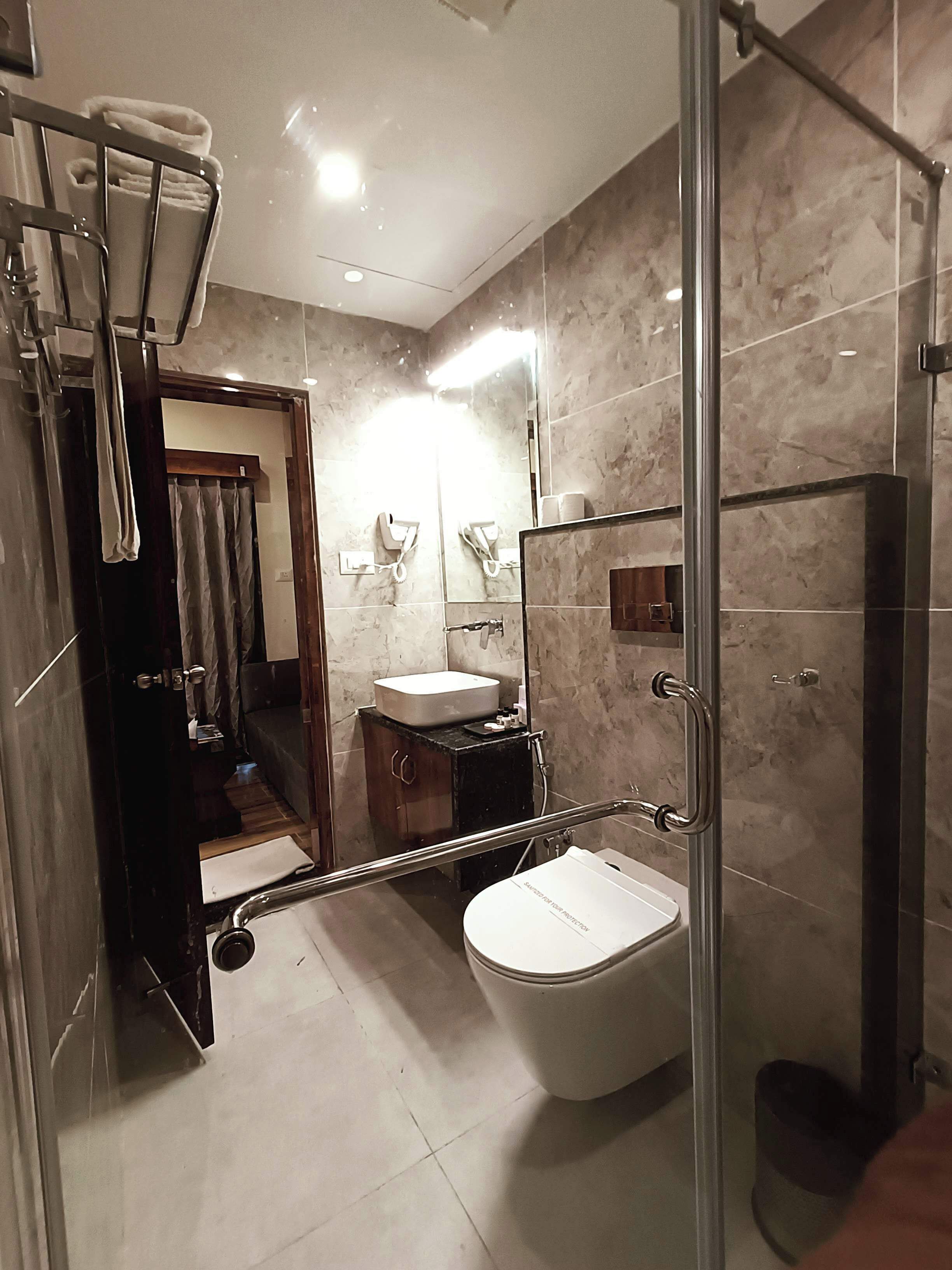 A modern bathroom with a glass shower enclosure, a white toilet, and a vanity with a sink.
