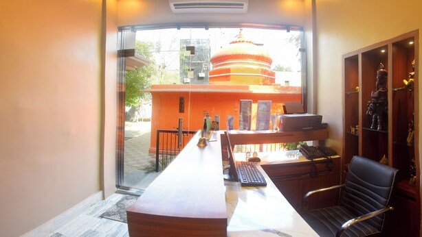 A reception desk with a computer, telephone, and seating area. - THE KASHI RESIDENCY  (Varanasi)