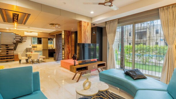 Una sala de estar moderna con un sofá, televisión y comedor.