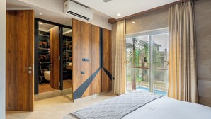 Un dormitorio con una cama grande, un armario y una puerta corredera que da a un baño.