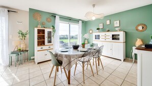 Un coin repas comprenant une table ronde, des chaises et un meuble avec des étagères.