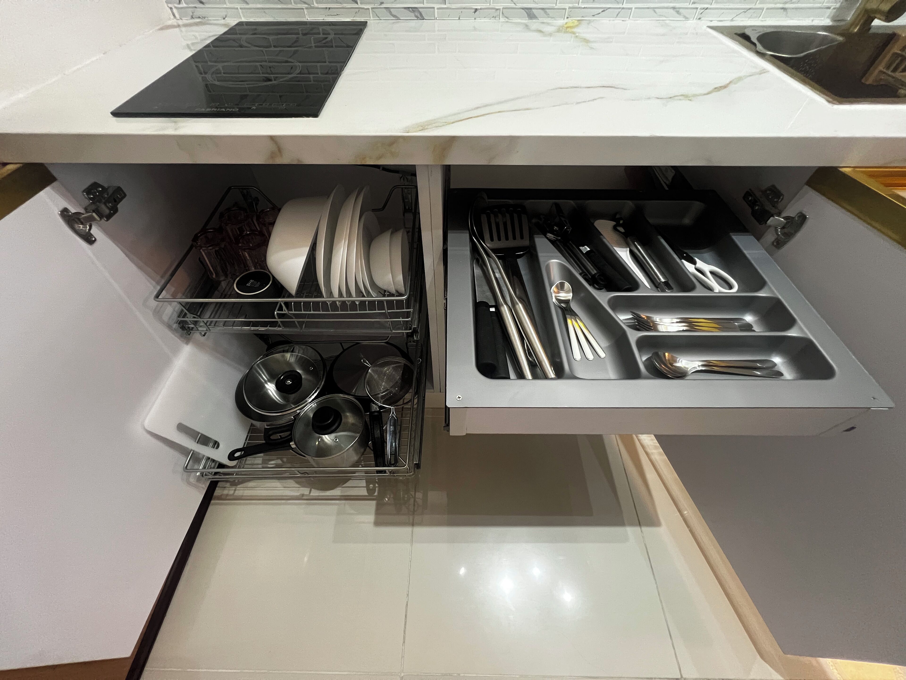 Una cocina con lavavajillas integrado y un organizador de cajones para utensilios.