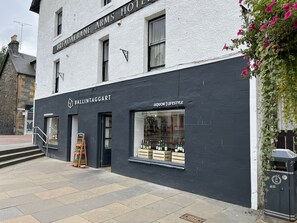 A building with a sign reading "BREAD ARMS HOTEL" and "BALLINTAGGART" with a liquor and lifestyle store on the ground floor. - Tay View (Aberfeldy)