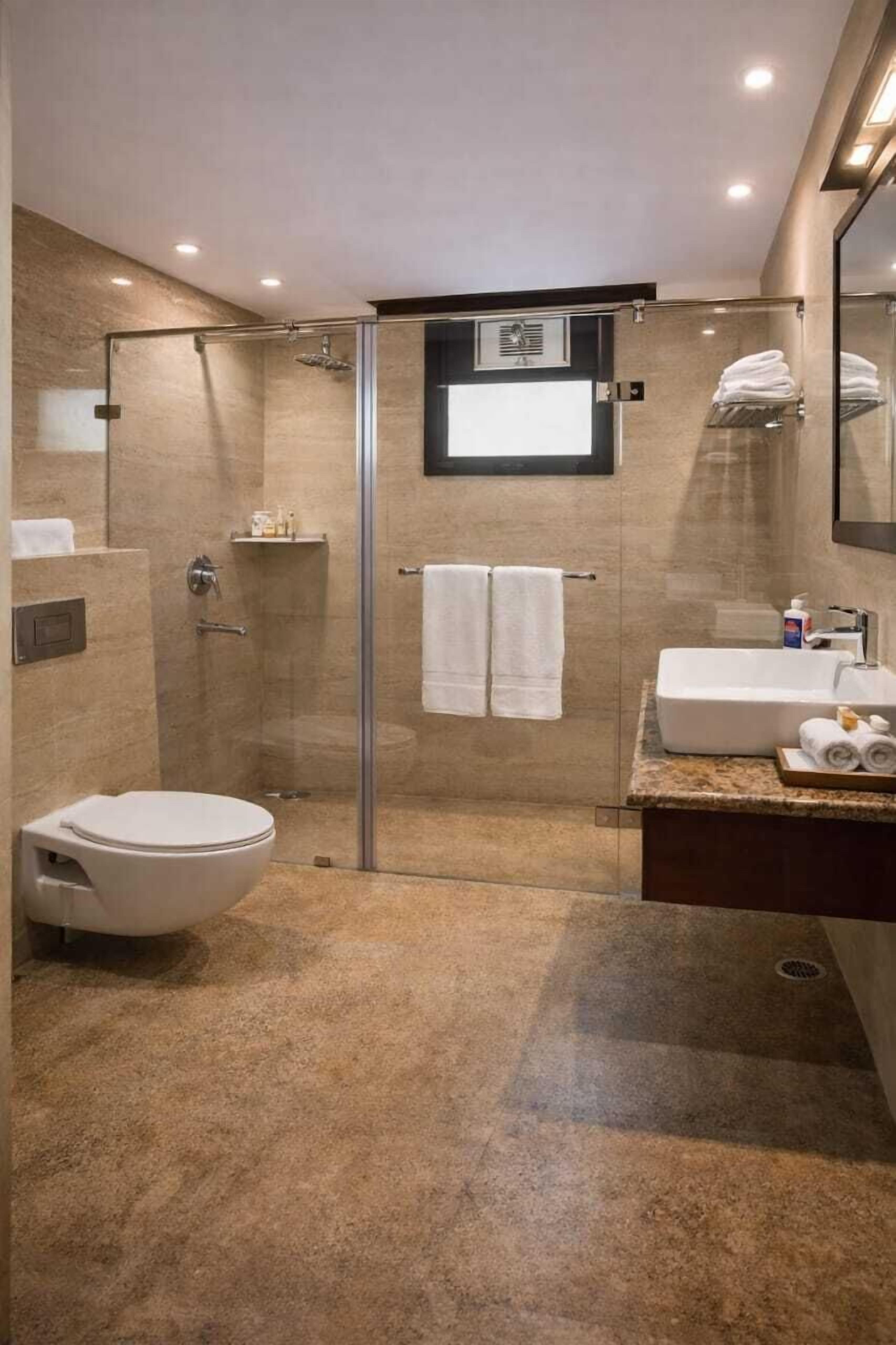Ein modernes Badezimmer mit einer Duschkabine, einer Toilette, einem Waschbecken und einem Spiegel.