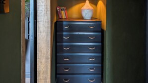 A dark wooden dresser with multiple drawers and a lamp with a striped lampshade.
