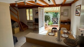 A kitchen with a dining area, a staircase, and a view of the garden. - Charming pavilion in Argelès-sur-Mer - Beach 5 min, air conditioning, pets allowed (Argelès-sur-Mer)