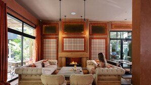 A cozy living room with a fireplace, comfortable seating, and large windows. - Saman Boutique Hotel (Valencia)