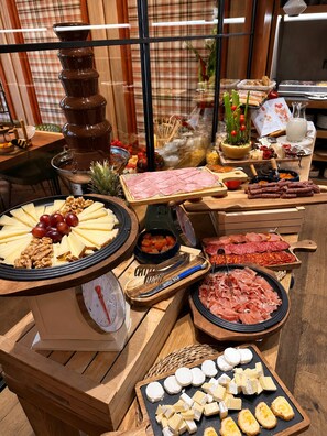 Een buffet met diverse kazen, vleessoorten en een chocoladefontein.