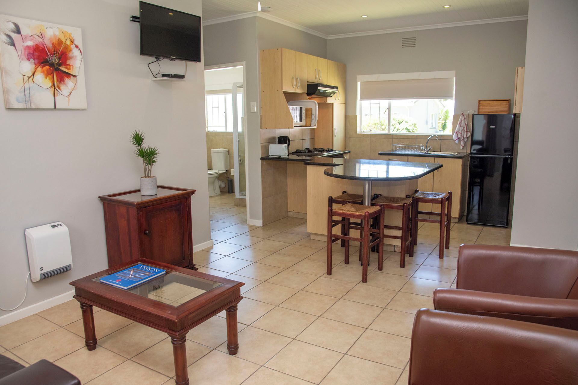 A compact living space with a kitchen, dining area, and a small office.