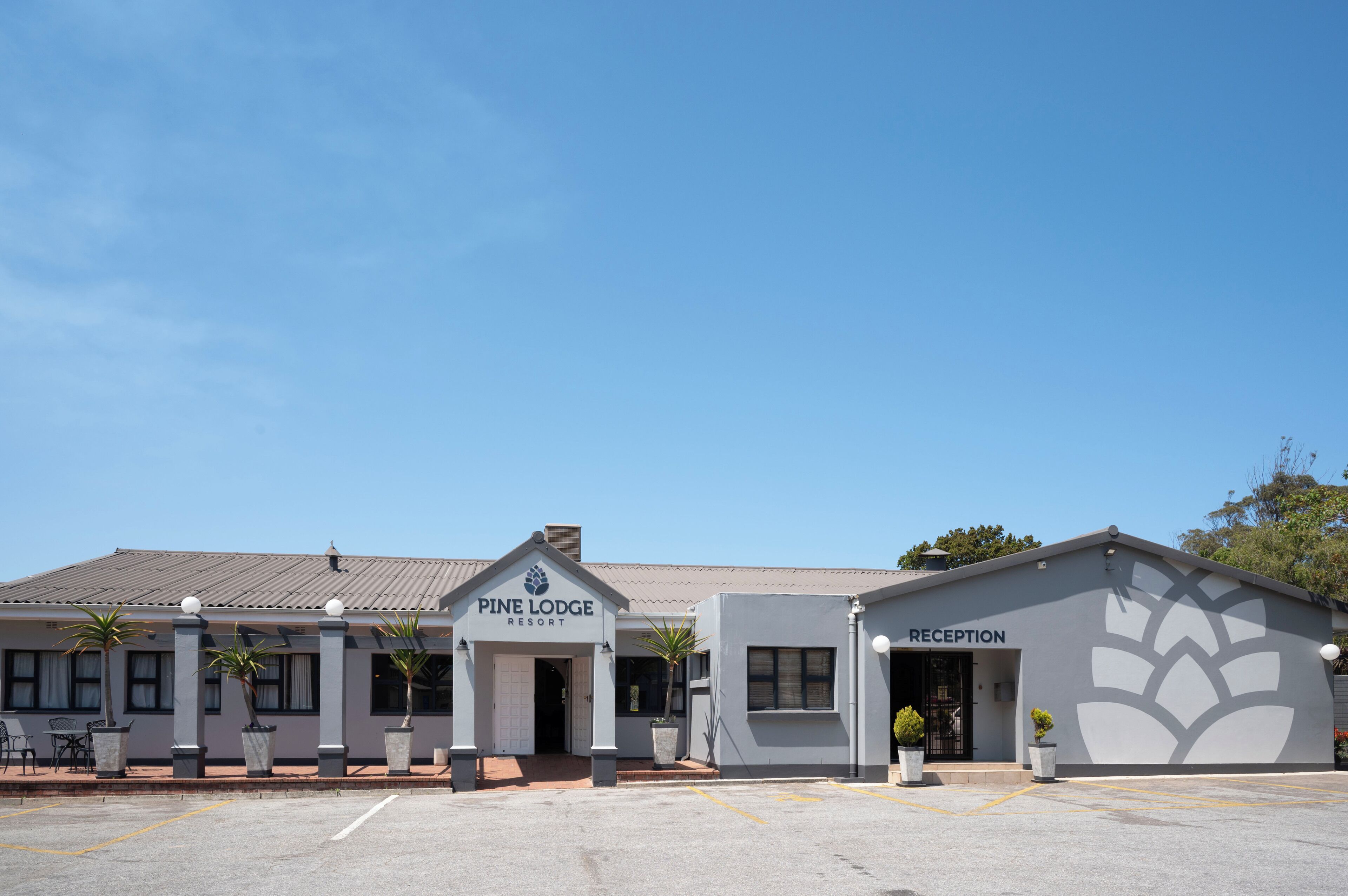 A Pine Lodge Resort building with a reception area and a parking lot.