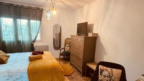 A bedroom with a bed, a dresser, a chair, and a desk.