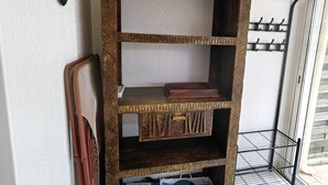 Een hoekrek met verschillende vakken, een kapstok en een deur met een decoratief patroon.