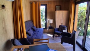 Une pièce moderne comprenant un canapé, des fauteuils, une table et une lampe.