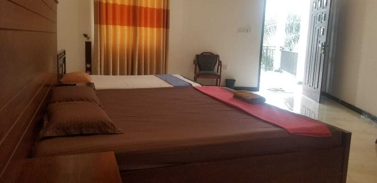 Een slaapkamer met een groot bed, een stoel en uitzicht op de omgeving.