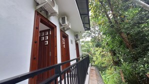 Un edificio con dos puertas de madera, cada una con un ventanal y una unidad de aire acondicionado instalada encima.