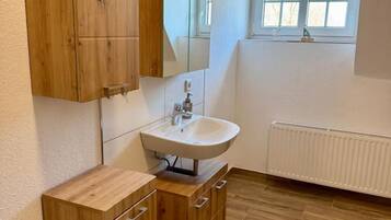 Een douche, handdoeken, zeep, toiletpapier