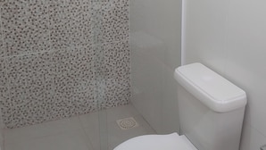 Ein Badezimmer mit Duschkabine, Toilette und Waschbecken.