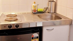 A compact kitchen with a microwave, stove, and sink.