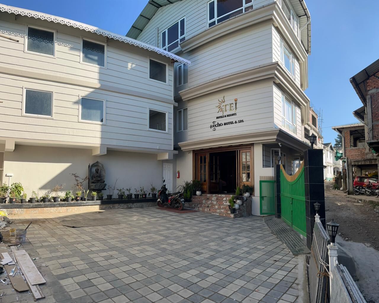 A hotel with a sign reading "Teji Hotel & Spa" and a gated entrance.