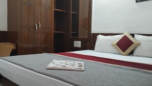 A hotel room with a bed, a desk, and a wardrobe.