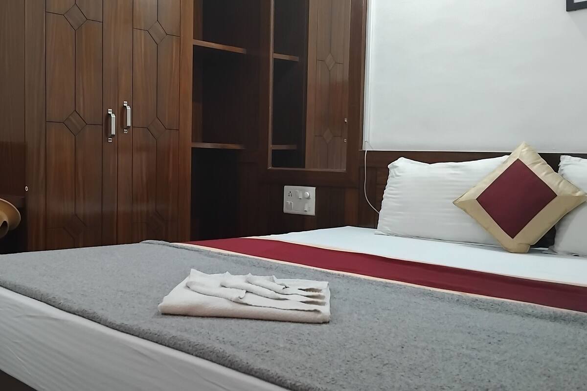 Una habitación de hotel con una cama, un escritorio y un armario.