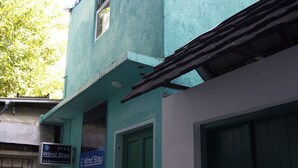 A building with a green door and a sign for Wind Stay. - WIND STAY Guest House (Malé)