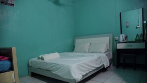 A small, single-bed room with a white bedspread, a wooden nightstand, and a mirror above a dark-colored dresser. - WIND STAY Guest House (Malé)