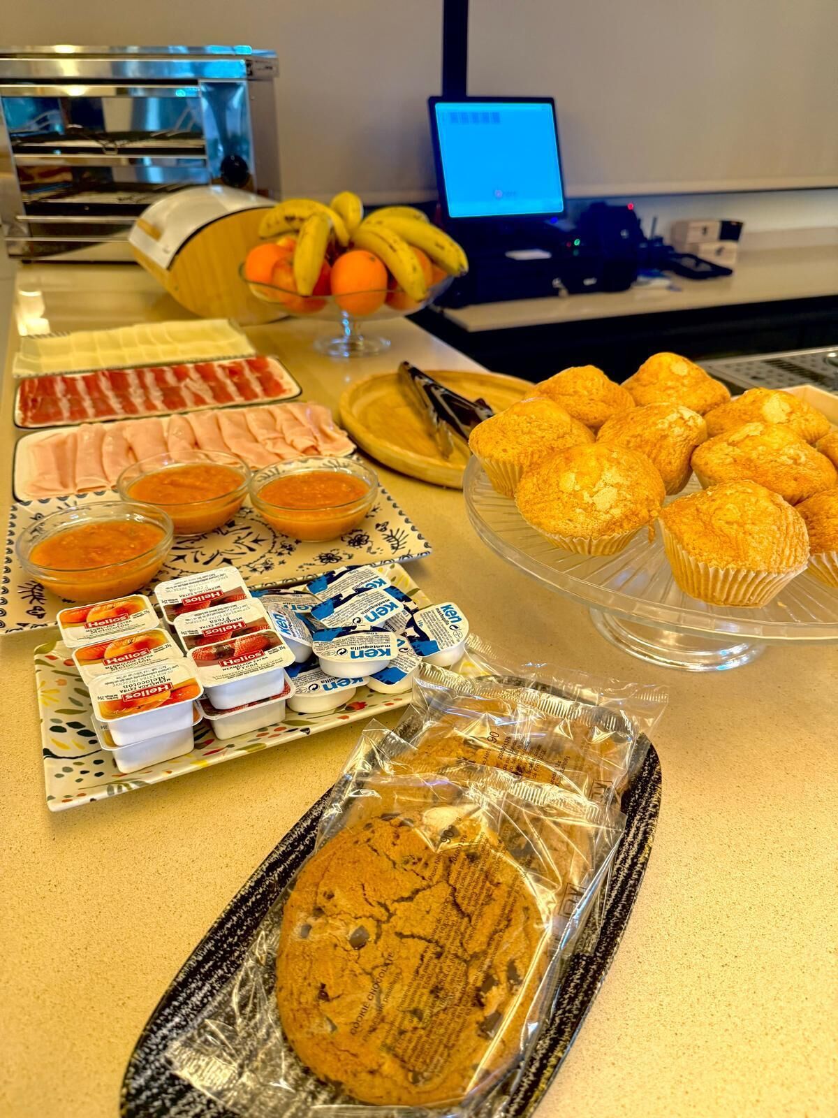 A buffet table with various food items including pastries, cookies, and condiments.