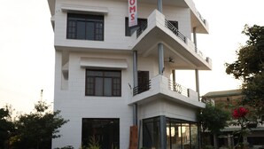 A modern two-story building with a sign reading "ROOMS" on the side. - River View Resort (Haridwar)