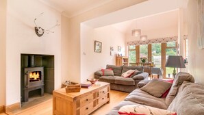 A cozy living room with a fireplace, a sofa set, and a wooden coffee table.