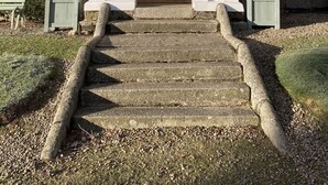 A stone building with a red roof, white columns, and a set of stone steps leading to a door. - Sherramore Lodge -  a lodge that sleeps 19 guests  in 10 bedrooms (Laggan)