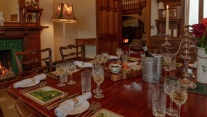 A dining table set with fine china, crystal glasses, and a wine bottle. - Sherramore Lodge -  a lodge that sleeps 19 guests  in 10 bedrooms (Laggan)